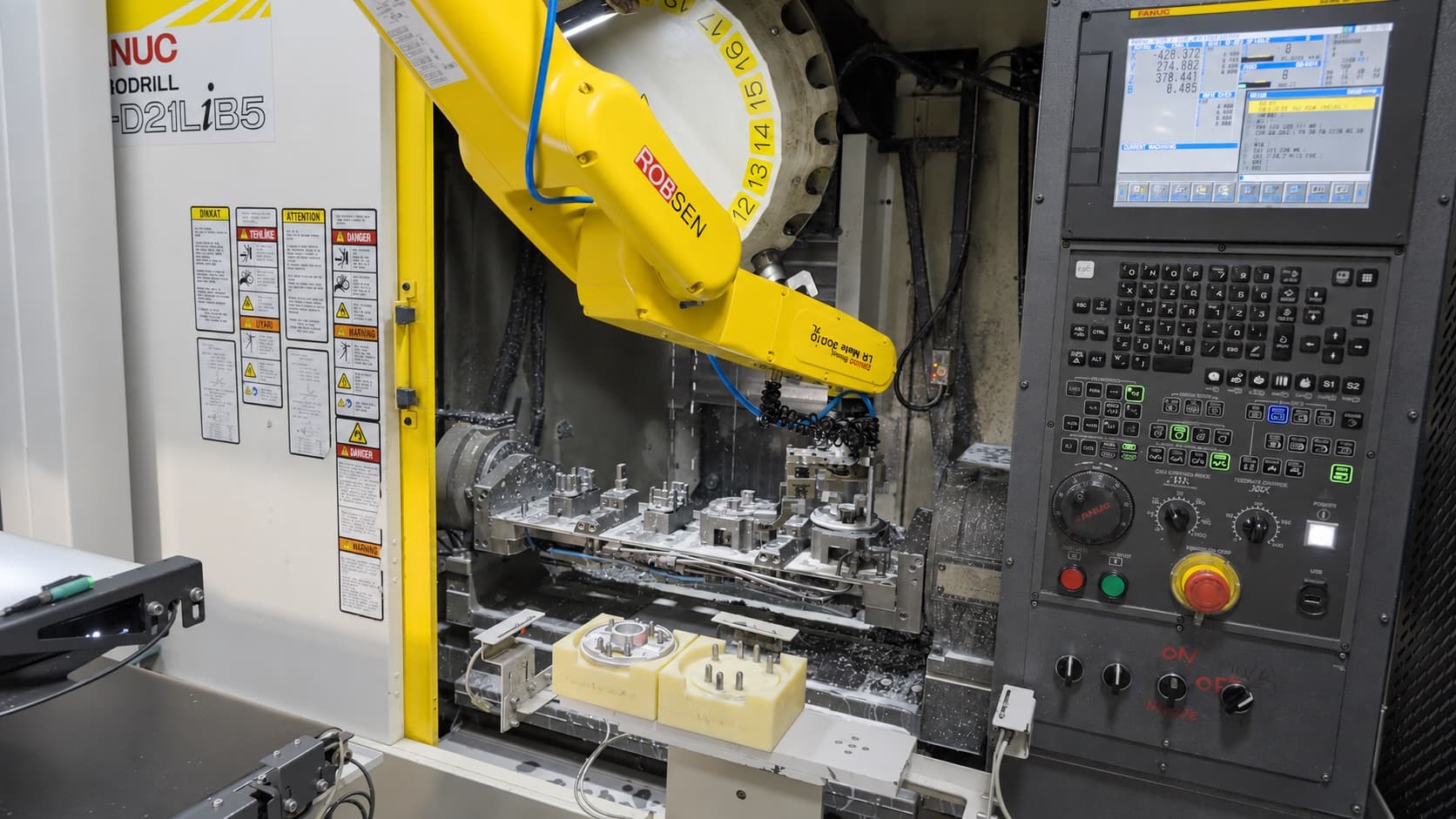 FANUC robot loading automatically operated fixtures inside a Robodrill CNC machining centre.